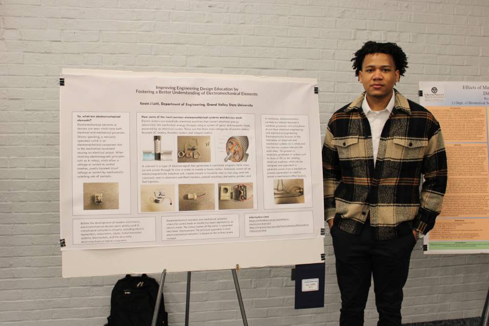 Student stands next to presentation